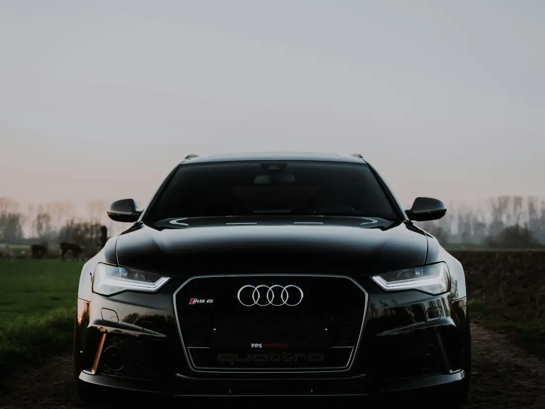 Black executive sedan photographed head-on at dusk.