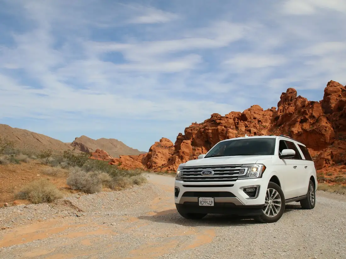 Full-size SUV standing on open ground under a wide sky.