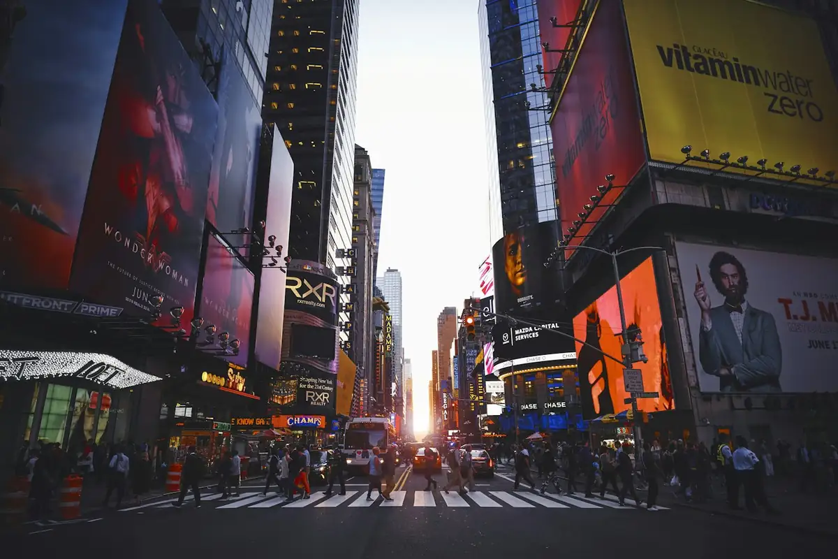 Times Square at street level, screens lit against the evening.